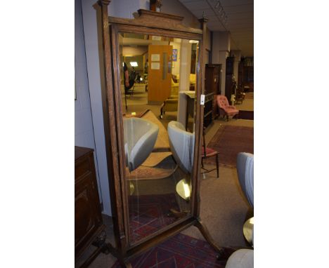 A Victorian oak cheval mirror with bevelled glass, raised on ceramic castors.