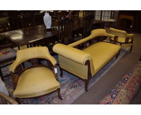 A Victorian walnut salon suite, comprising: chaise longue and a pair of open armchairs, the legs terminating in ceramic casto
