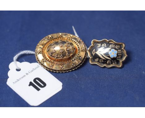 A Victorian yellow metal and black enamel mourning brooch, inscribed 'In memory of' around a Forget-Me-Not, with plaited hair