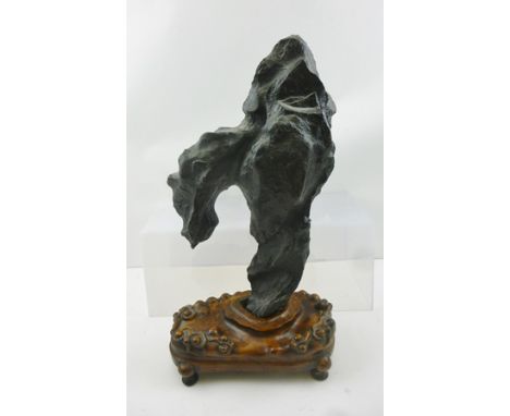A BLACK LINGBI LIMESTONE SCHOLAR'S ROCK OR GONGSHI, considered to be 18th century, complete with carved hardwood stand, overa