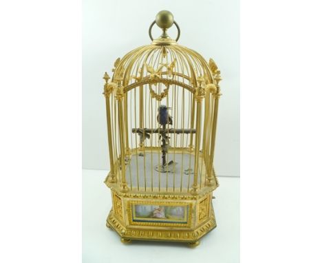 A LATE 19TH CENTURY AUTOMATON FRENCH MUSICAL BIRD IN A GILDED CAGE, the top of the cage with ring mount, cast with birds and 
