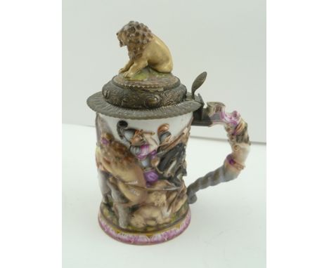A CAPO-DI-MONTE RELIEF FORM CERAMIC "LION HUNT" TANKARD, polychrome decorated, the hinged metal cover with porcelain seated l