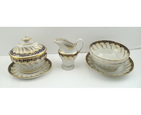 A CAUGHLEY PORCELAIN SUGAR BOWL WITH COVER AND STAND, having cobalt blue borders, leaf gilded, the oval box with gilded faux 