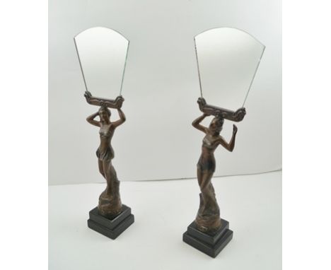 A PAIR OF FRENCH ART DECO DESIGN BRONZED SPELTER FIGURES, raised on ebonized squared wood bases, holding aloft, mirrors, 46cm