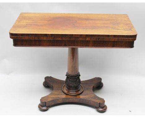 A 19TH CENTURY ROSEWOOD FOLD-OVER CARD TABLE, raised on tapering stem with carved acanthus leaf base, on shaped platform and 