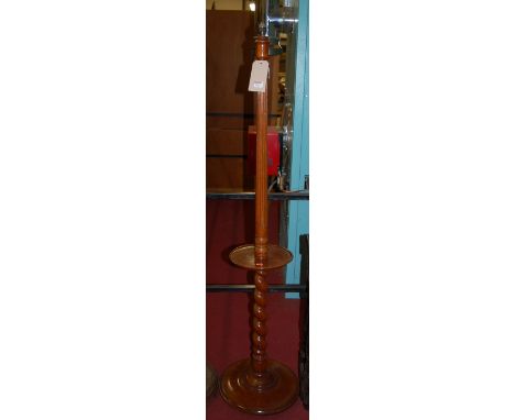A walnut fluted and barley twist turned standard lamp, having a dished centre