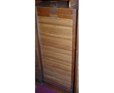 A 1930s light oak tambour fronted office filing cabinet, height 117cm
