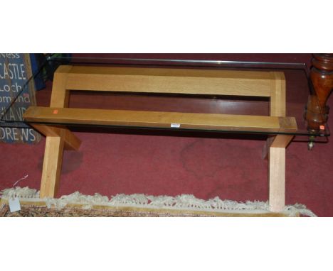 A contemporary light oak and glass topped rectangular coffee table