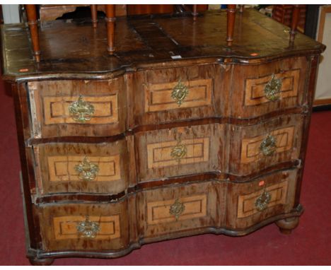 An 18th century south German walnut and burr walnut commode of shaped form, having three long drawers on bun supports, width 