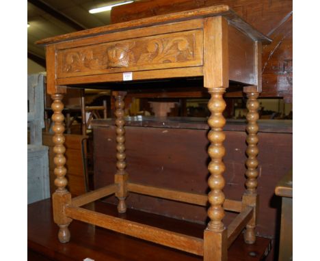 A circa 1900 carved oak single drawer side table, raised on bobbin turned supports