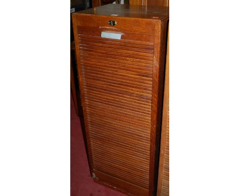 A 1930s light oak tambour fronted office filing cabinet, height 117cm Condition Report / Extra Information Colour generally g