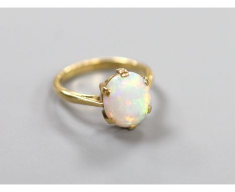 An 18ct and oval white opal set ring, size N, gross weight 3.6 grams.