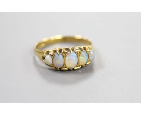 An 18ct gold and graduated oval white opal set half hoop ring, size Q/R, gross weight 3.4 grams.