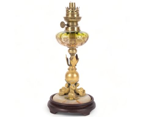 A small gilt-metal oil lamp on an onyx and turned wood base,  with an engraved green glass font, H34.5cm,No font or shade, ge