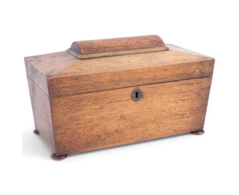 A Regency rosewood tea caddy of sarcophagus form, with fitted inner lids and mixing bowl, and silver caddy spoon, sitting on 