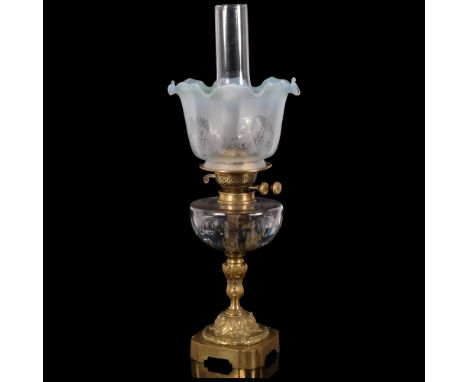An Antique brass oil lamp, with coloured frilled edge shade and glass font on an embossed brass base, H56cmGood overall condi
