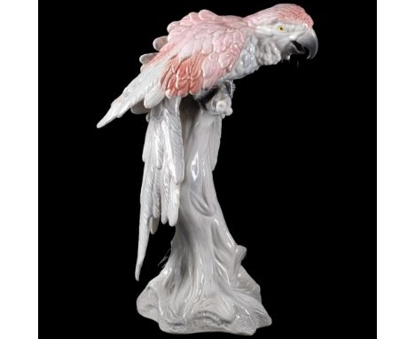 A large Italian porcelain sculpture of a parrot sitting on a tree trunk, signed, 51cm 