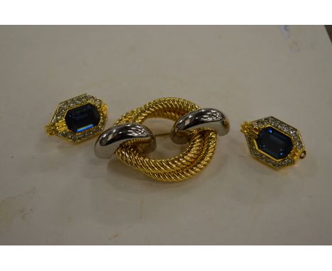 Christian Dior earrings and a decorative brooch.