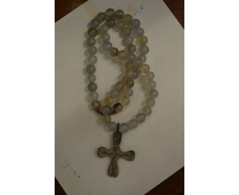 A Roman bronze cross on a bead necklace.