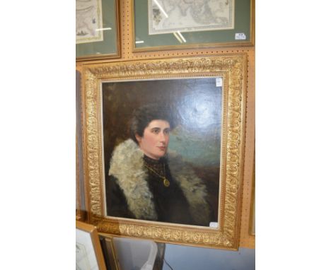 A bust length portrait of a young lady wearing a fur trimmed coat, oil on board, in a decorative gilt frame.