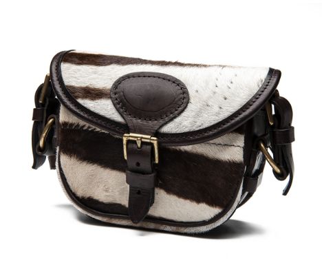 A ZEBRA HIDE AND LEATHER SMALL CARTRIDGE BAG,with canvas and leather shoulder strap and brass fittingsS5 - Sold as a Section 