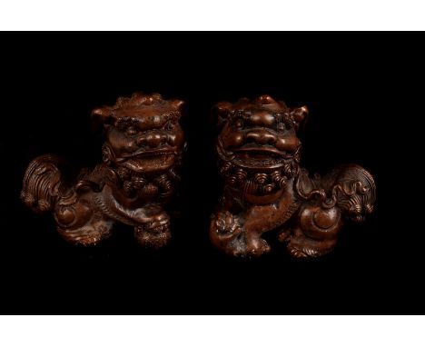A vintage pair of Chinese bronzed Bhuddist Temple Dogs, each of the dogs of fo stood with a paw on a ball, drill holes to und