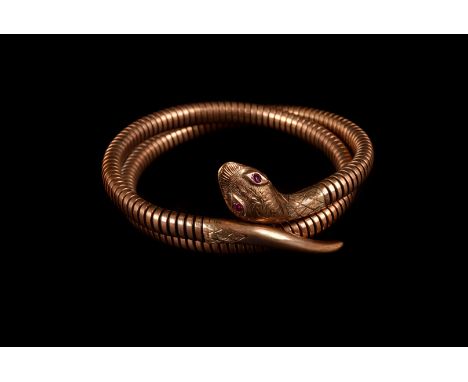 A 9ct gold snake bangle, the stretchy body leading to a decoratingly engraved head, having synthetic ruby eyes, approx 30g
th
