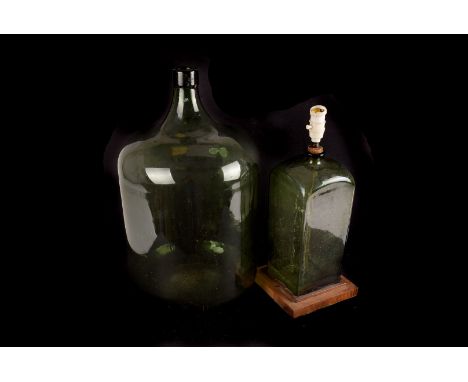 A large green carboy, plus a 19th century square based green glass bottle as a lamp base, a spirit barrel lamp base, and a wh