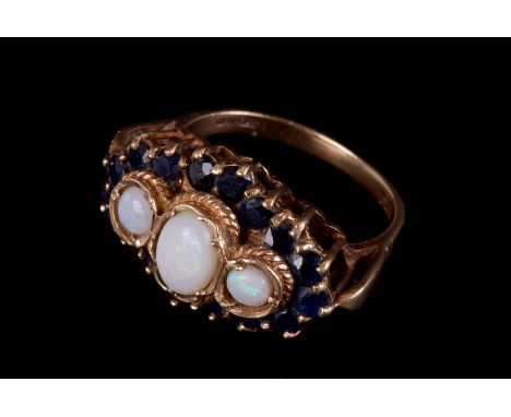 A 1970s 9ct gold opal and sapphire dress ring, the tablet set with three polished white opals surrounded by small blue stones