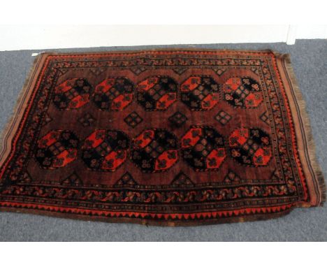 A Middle Eastern woollen carpet, with burgandy ground and ten medallions with clover or small flower head motifs, approx 140c