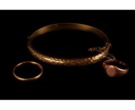 An 18ct gold band, together with a 9ct gold signet ring and a 9ct rolled gold bangle with engraved design to one half (3)