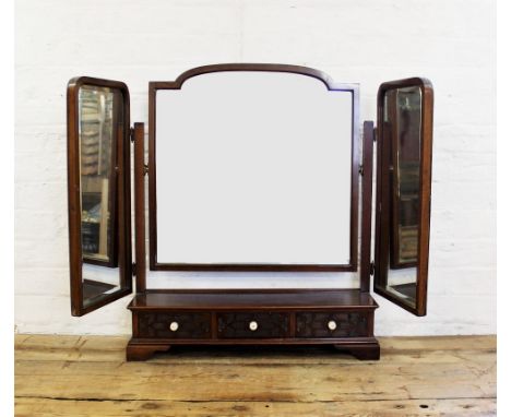 A 1920's Chinese Chippendale revival mahogany triple dressing table mirror, the three bevelled mirrors raised above a plinth 