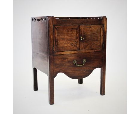 A George III mahogany tray top commode/cabinet, with a pierced gallery above a pair of cupboard drawers and a single drawer, 