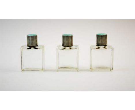 A set three George V silver and enamel topped scent bottles, Goldsmiths & Silversmiths Co Ltd, Birmingham 1930, the moulded r
