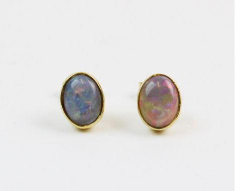 A pair of opal stud earrings, each comprising an oval opal cabochon measuring 8mm x 5mm, collet set to a plain polished yello