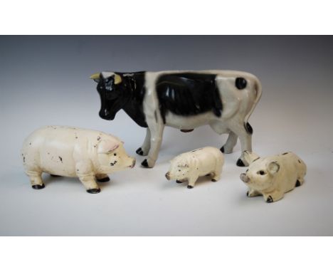 A group of three novelty piggy banks, 20th century, each with cold painted metal body, modelled standing and lying down, larg
