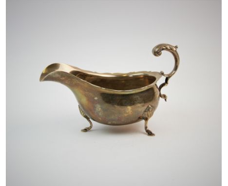 A silver sauce boat, F C Richards, Birmingham 1945, of typical plain polished form, with scalloped rim and scrolling foliate 