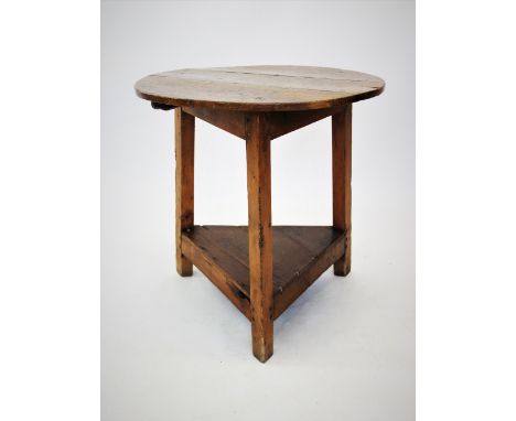 A 19th century elm and pine cricket table, the circular elm top raised upon three pine angled legs with triangular under shel