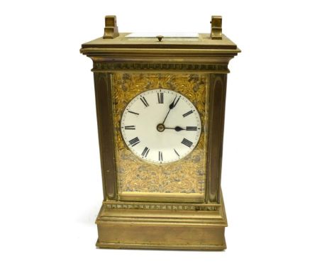 A BRASS CASED 8-DAY CARRIAGE CLOCK  the enamel dial with Roman numerals, movement chiming on a coiled gong, with repeat butto