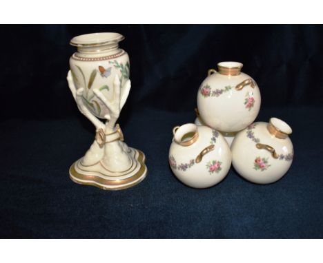 A ROYAL WORCESTER VASE  modelled as three bird's claws clasping the ovoid receptacle on a trefoil base. painted with butterfl