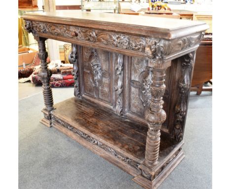 A CARVED OAK BUFFET  with frieze drawer flanked by lion masks above carved pilasters and pot shelf base, 142cm wide