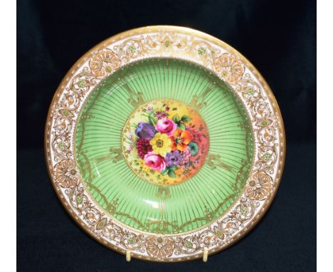 A ROYAL WORCESTER DISH  the centre painted with a spray of flowers signed by William Hale, on a green ground within jewelled 