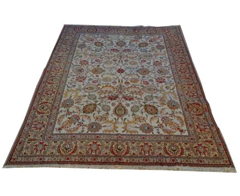 A Tabriz carpet, the bold floral scrolls on ivory-coloured ground, 426 x 320cms.