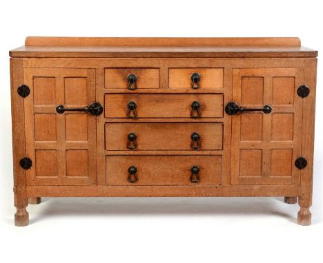 Robert 'Mouseman' Thompson of Kilburn: a mid Century oak sideboard, with shaped back and adzed rectangular top above a centra