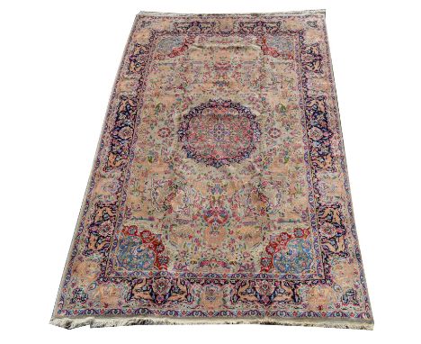 A Kirman carpet, the floral design and scrolling field on beige ground, 298 x 183cms. 