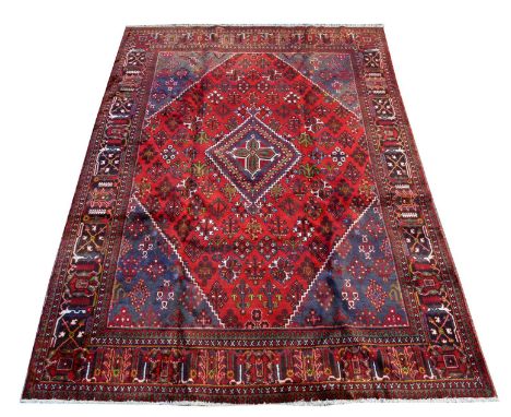 A Joshaghan carpet, the diamond-shaped medallion and floral sprigs on red ground, 348 x 243cms. 