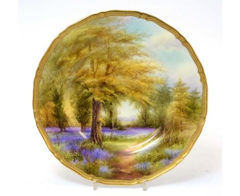 A Royal Worcester plate by Raymond Rushton (1886-1956), painted with 'Bluebells. Kew Gardens', signed and titled to the rever