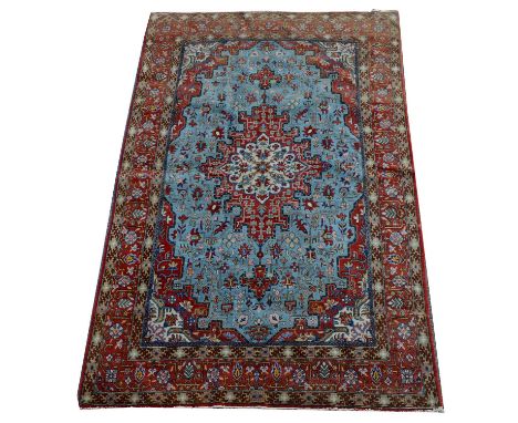 A Qum rug, with floral medallion and light blue field, 219 x 138cms. 