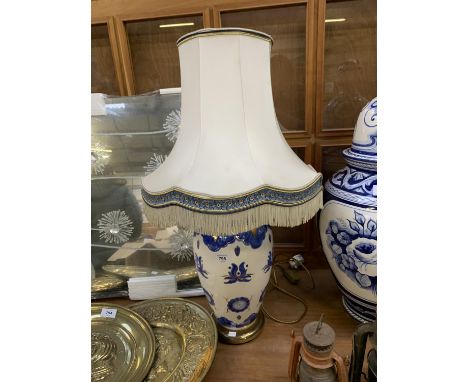 A LARGE BLUE AND WHITE PORCELAIN LAMP BASE TOGETHER WITH TASSELED SHADE 