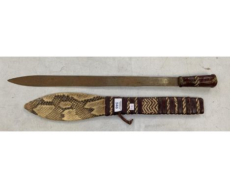 A TRIBAL LEATHER AND HANDLED SWORD WITH MATCHING LEATHER AND SNAKESKIN SCABBARD 